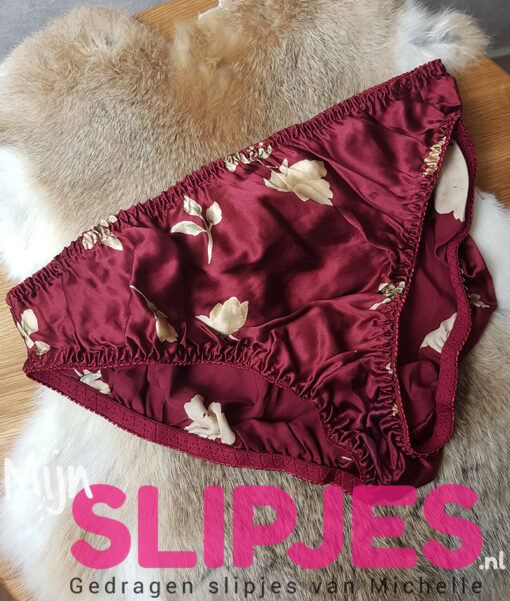 Gedragen rode zijden slip met bloemen motief